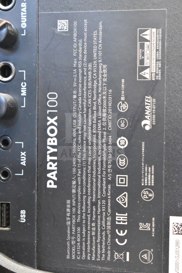 JBL PartyBox 100 speaker back panel showing input ports, labels, and certification markings.