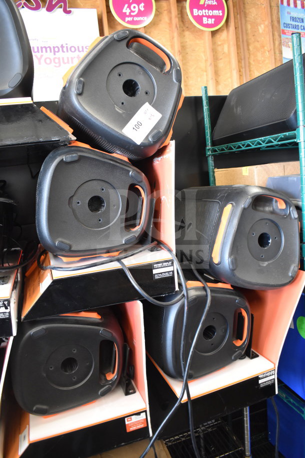 5 JBL speakers displayed on store shelves, in good condition. Includes visible tags indicating auction and promotional details.