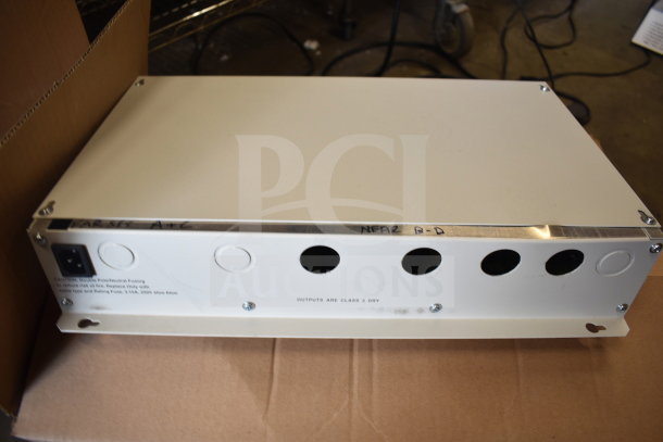 Sensormatic AMS-9060 Surveillance Controller, white, rectangular, metal casing, labeled "OUTPUTS ARE CLASS 2 DRY".