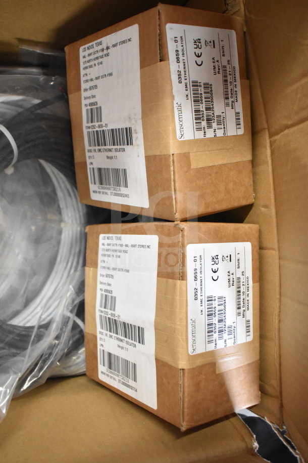 Box of wires and two Sensormatic 0352-0659-01 Ethernet Isolators in packaging, labels indicating model and specs.