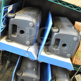 Four Onn speakers used in store displays, black with visible ports, on metal shelves. Condition appears used.