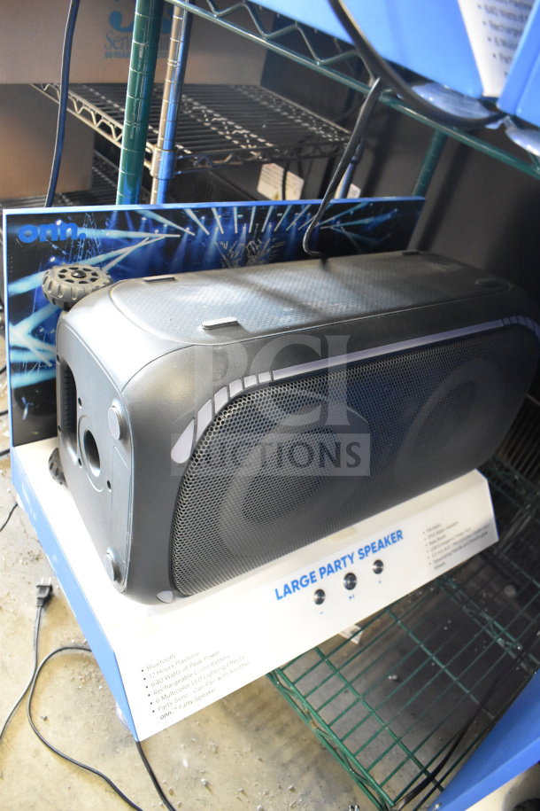 Onn large party speaker on a store display rack, featuring Bluetooth, 12-hour runtime, and rechargeable battery.