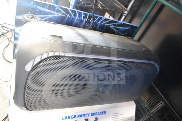 Onn large party speaker display, featuring dual subwoofers, sleek black design, promotional backdrop included.