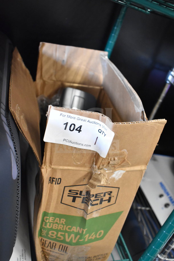 Cardboard box containing a Tellermate calculator. Box marked with "104 QTY 1" label, suggests auction item listing.