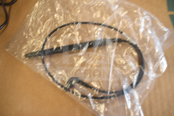 A plastic bag containing black wire and probes, part of a Tellermate calculator accessory set.
