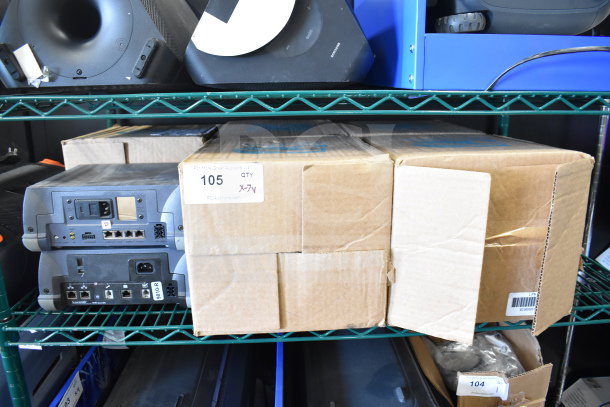 Shelf with Sensormatic ZBSMPROE and other electronics. Items are boxed; visible labels indicate lot number 105, qty X-7V.