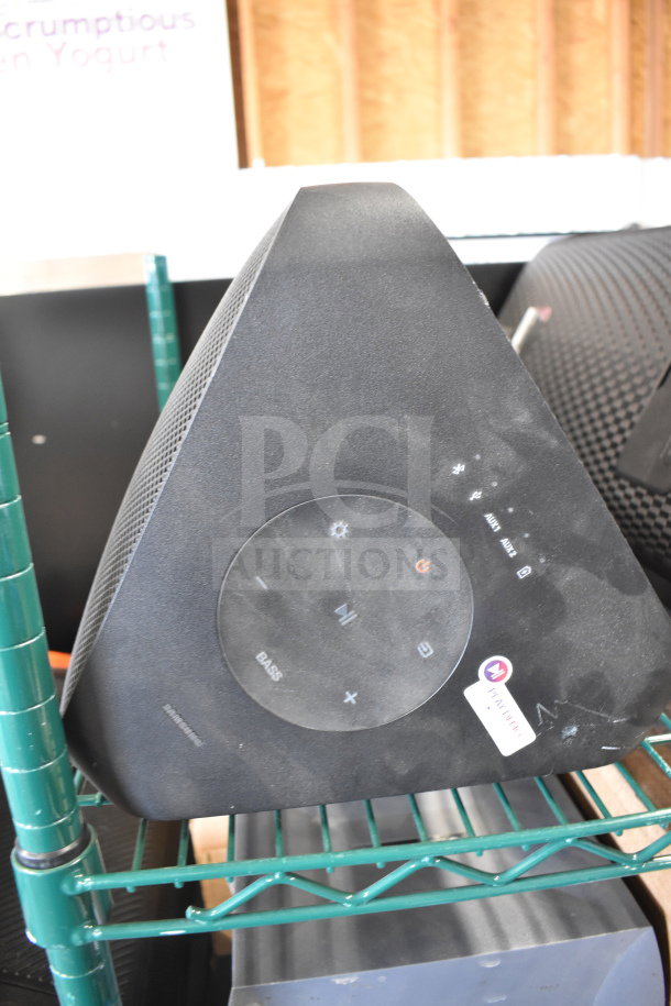 Triangle-shaped Samsung speaker display, black with visible controls, slight wear, labeled "Samsung." Includes two other displays.