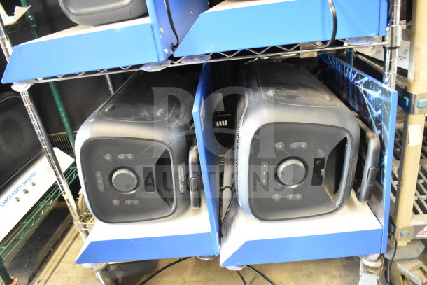 Two Onn large party speakers on store display shelves, featuring black design and control panels, in used condition.
