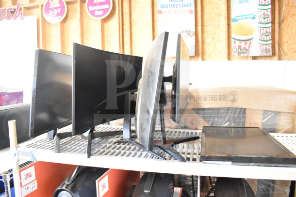 Five various monitors including Vizio, Onn, MSi, Samsung, on a shelf. Mixed sizes, black frames, used condition.