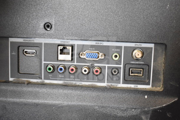 Rear panel of a monitor showing HDMI, Ethernet, RGB, and audio ports. Includes USB and cable/antenna inputs.