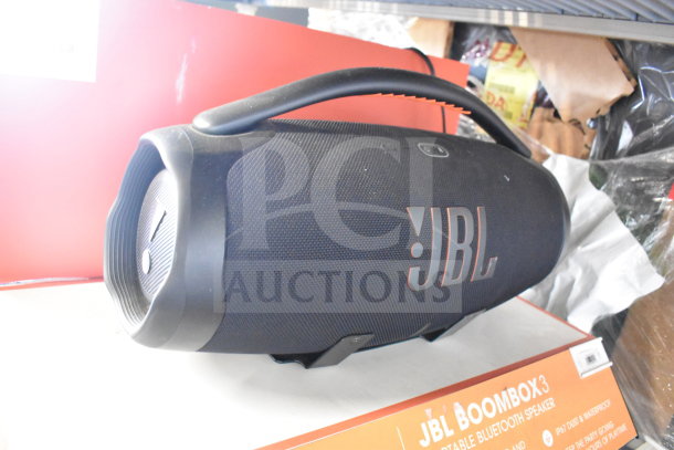JBL Boombox3 speaker on display box, black with logo, portable Bluetooth, waterproof, premium sound quality.