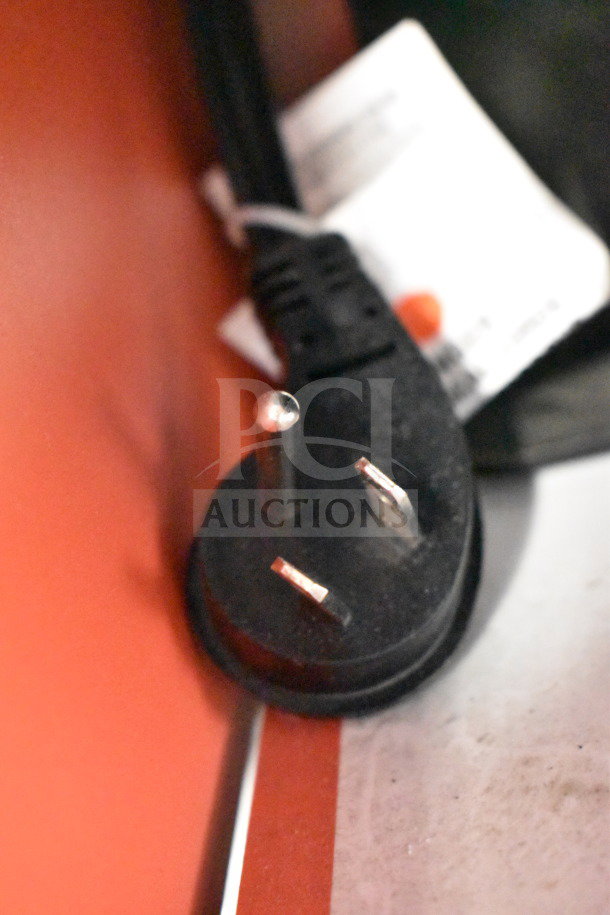 Australian plug attached to a JBL Boombox 3 speaker, showcased in a store display. Black cord and visible label.