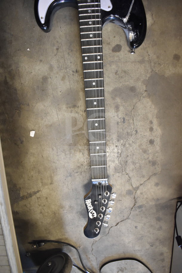 RockJam electric guitar with black body, visible guitar neck wear, and RockJam logo on headstock. Appears used.