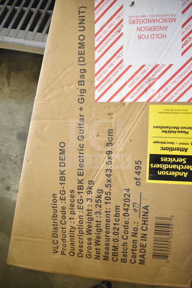 Cardboard box labeled with VLC Distribution, product code EG-1BK Demo, containing Rock Jam electric guitar with gig bag, item weight 3.25 kg, made in China.