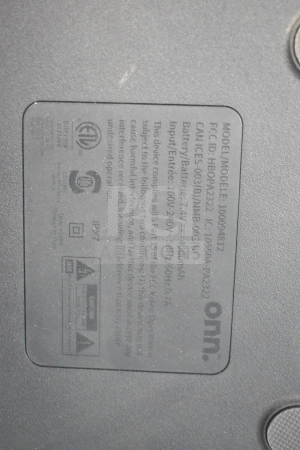 Label on Onn medium party speaker model 100094812, showing power input, battery info, and compliance logos.