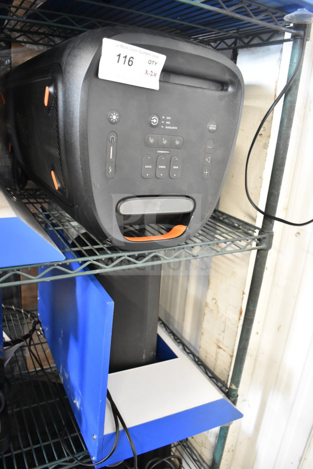 JBL PartyBox310 speaker on metal shelf, black with orange accents, control panel visible, auction tag marked "116 X-2y."