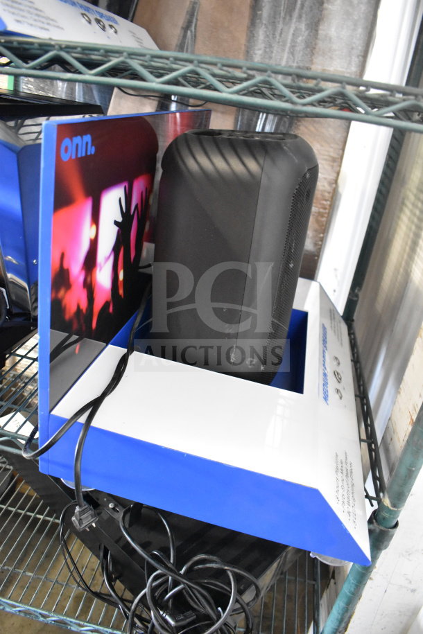 JBL PartyBox310 speaker with cables, displayed on a blue and white stand. Features vibrant sound visuals.