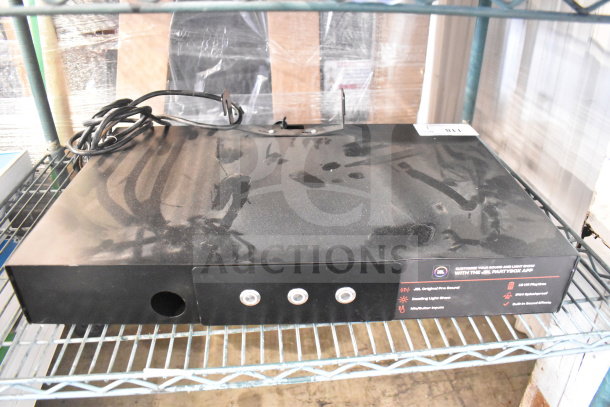 Black JBL speaker store display unit with multiple control buttons, power cord, and promotional labels. Visible dust and minor wear.