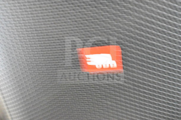 Blurred close-up of a speaker grille with a red JBL logo. Auction includes JBL PartyBox 110 Speaker with store display.