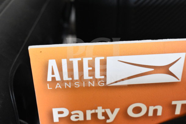Altec Lansing store display featuring speaker; orange sign with logo and text "Party On." Good condition.