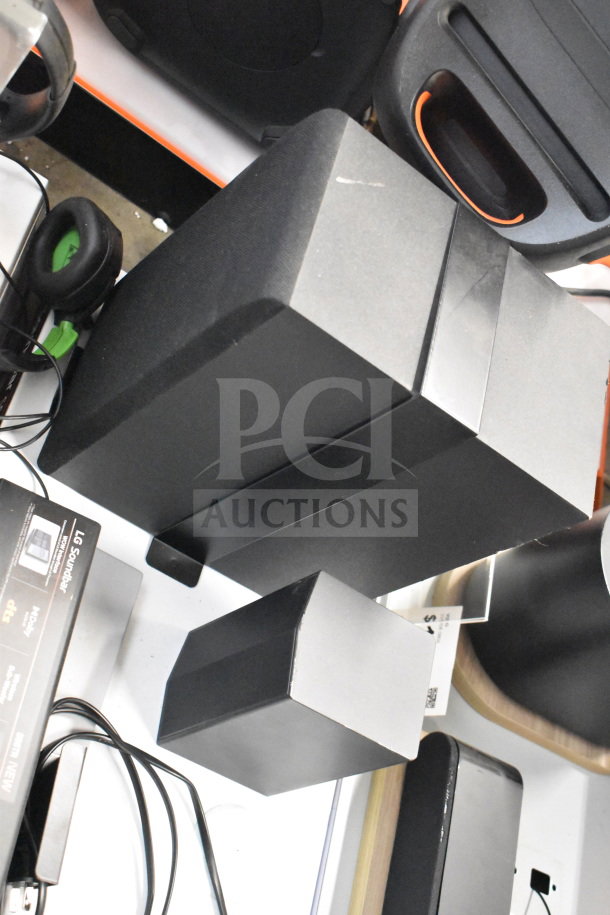 Store display with gaming headphones, LG soundbar boxed, cables visible. Appears in good condition.