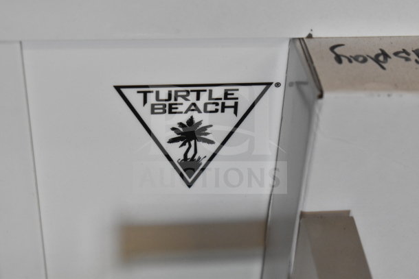 Turtle Beach logo on a white display. Part of 3-store gaming display with screen, headphones, and LG soundbar.