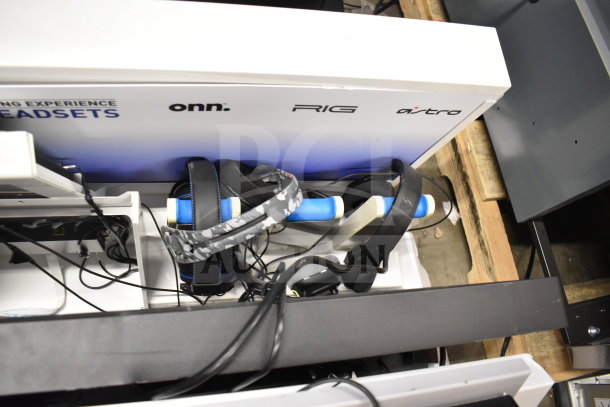 Store display with headphones from onn., RIG, and Astro brands, featuring multiple headsets on a white shelf.