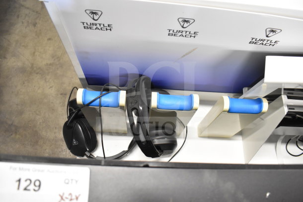 Turtle Beach store display with headphones on blue holders, featuring the brand logo. Display appears in used condition.