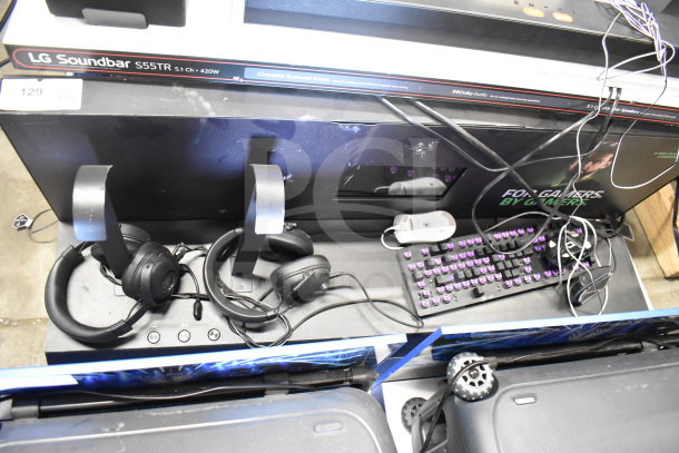 Store display with LG S55TR soundbar, headphones, wired mouse, and purple-lit keyboard. Items show wear but include necessary accessories.