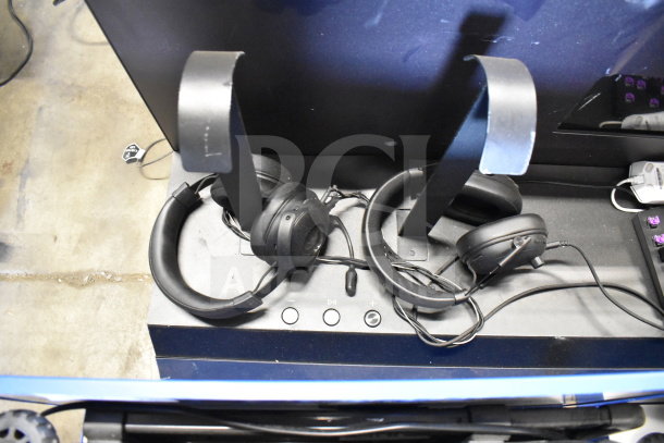 2 store display with two black headphones on stands, control buttons visible, in good condition.