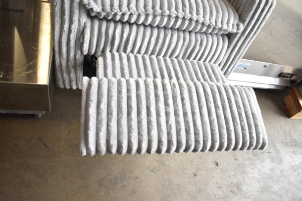 Gray armchair with plush ribbed fabric and extended footrest. Modern design, excellent condition.
