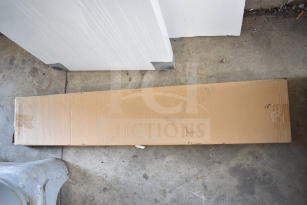 Brown cardboard box containing a ServIt 423GST3WELP steam table, brand new with minor scratches and dents. Box on concrete floor.