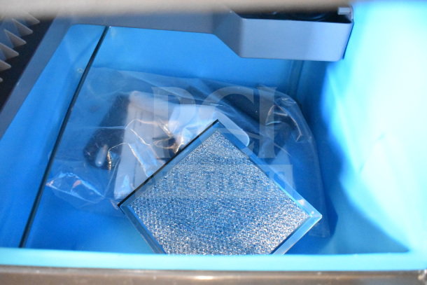 Brand new Manitowoc UDP0065A-161 undercounter ice machine bin interior with packaging.