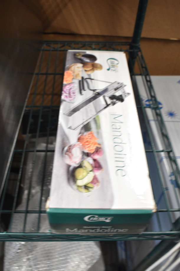 BRAND NEW SCRATCH AND DENT Choice 407SSMANO3IB Stainless Steel Mandoline in box with 2 blades and julienne set visible.