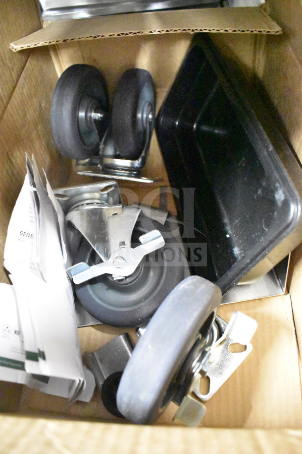 Box containing caster wheels, metal brackets, and a plastic tray, likely accessories for a Mainstreet 541HPU1812 cabinet.