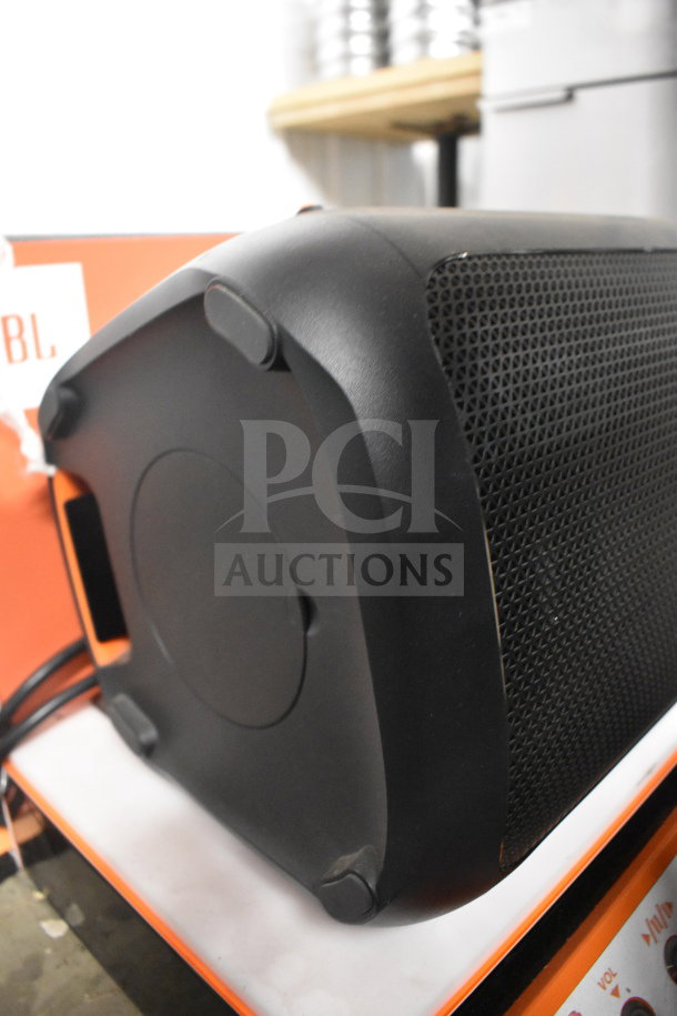 Black JBL speaker on store display, featuring a mesh grille and sturdy base. Barely used; includes box with product branding.