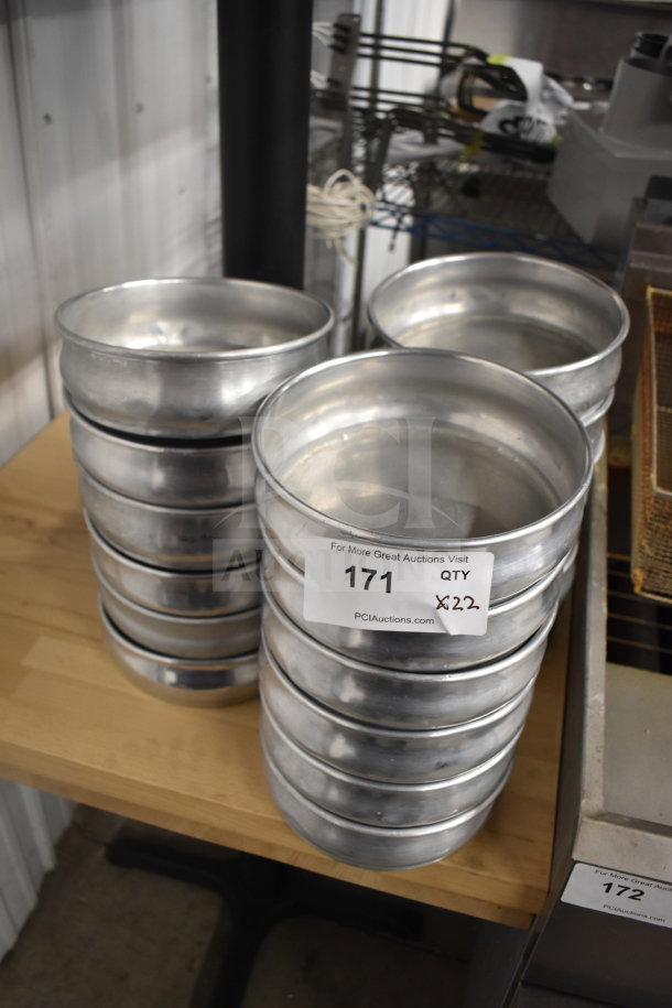 22 aluminum round baking pans stacked, good condition. Auction label reads "171, Qty 22."