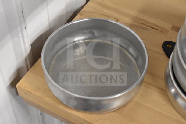 Aluminum round baking pans in used condition, stack of 22. Ideal for bulk baking needs.