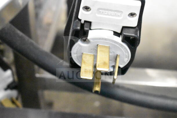 Close-up of a Hubbell electrical plug connected to the Turbochef HhC2020 oven, highlighting power connection.