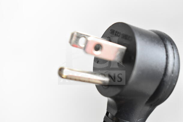 Close-up of a black, two-flat and one-round prong electrical plug with engraved text.