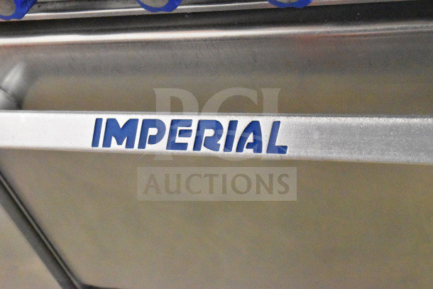 "Imperial" logo on commercial natural gas 6 burner range with oven, over shelf, and backsplash.
