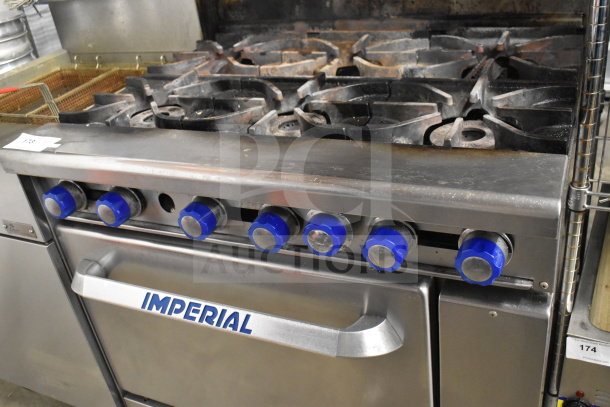 Imperial gas range with 6 burners, oven, overshelf, backsplash; blue knobs, branded handle, visible wear.