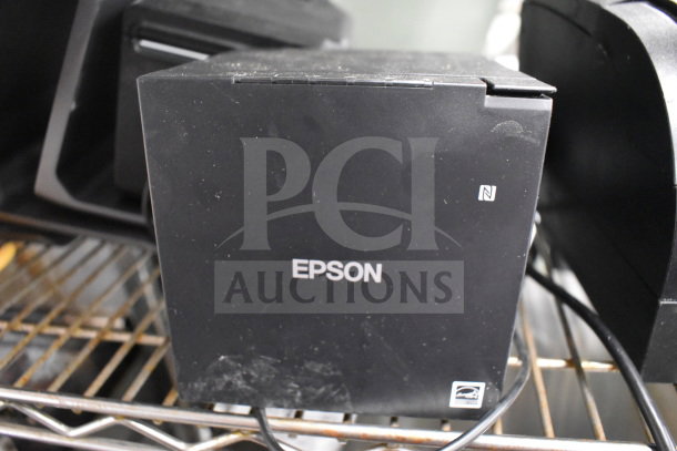 Seven receipt printers including SNBC BTP-S80 and Epson M374C, in used condition, on metal shelf.