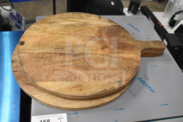 Wooden paddle with handle, round shape, natural wood grain visible, slight wear, part of a 9-item auction lot.