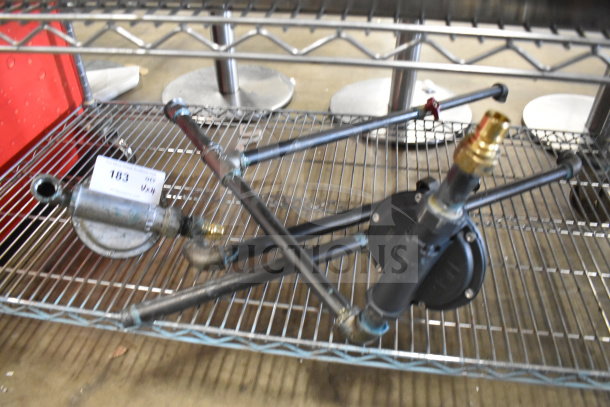 Various metal pipes with fittings on a wire rack; includes auction tag labeled "103."