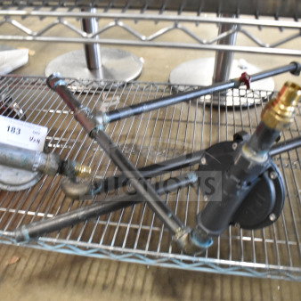 Various metal pipes with fittings on a wire rack; includes auction tag labeled "103."