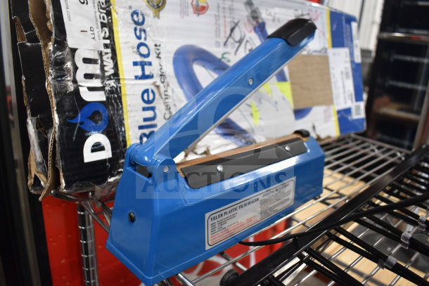 Blue Yeler Plastic Film Sealer, new condition, next to metal and black basket, part of a 6-item scratch and dent auction set.