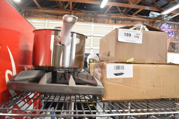 Brand new Vigor SS1 Series 7.6 Qt. stainless steel saucepan with aluminum-clad bottom, range grate, and boxed items.