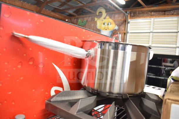 Stainless steel Vigor SS1 Series 7.6 Qt. sauce pan with lid, aluminum-clad bottom, displayed on a Southbend grate.