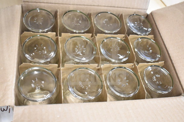 Box of new glass jars, neatly arranged, each with textured markings on the bottom.